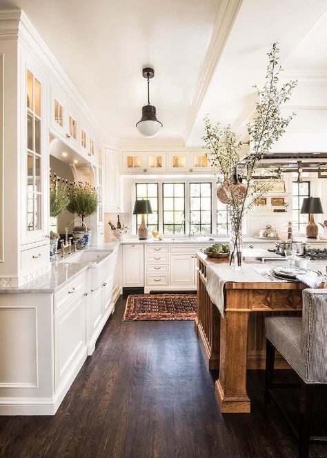 This expansive white and brown kitchen, lit by a Kelly Wearstler Precision Pendant, boasts a large brown wooden island seating black and white stripe counter stools at a wood countertop. French Country Kitchen Designs, Rustic Farmhouse Kitchen Cabinets, French Country Decorating Kitchen, Country Kitchen Designs, French Country Design, Farmhouse Kitchen Cabinets, Farmhouse Kitchen Design, Rustic Farmhouse Kitchen, Country Style Kitchen