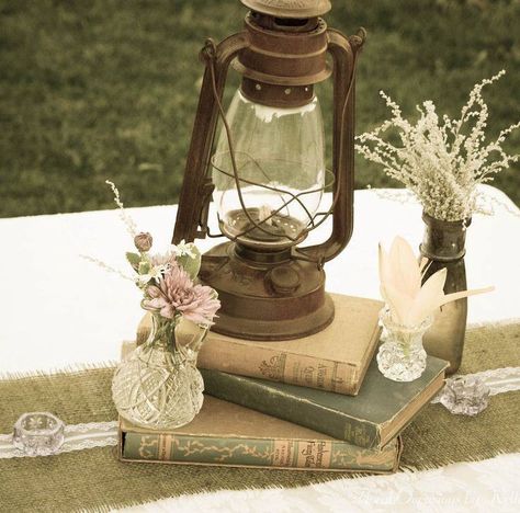 Centerpiece vintage More Vintage Lanterns Rustic, Oil Lanterns Wedding Centerpieces, Fairy Garden Wedding Ideas Indoor, Enchanted Wedding Reception Decor, Antique Lantern Centerpieces, Vintage Lantern Wedding Decor, Vintage Lantern Centerpieces, Old Books Wedding Decor, Antique Wedding Centerpieces