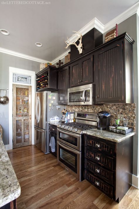 I like the rustic, but modern look of this kitchen, especially the screen door on the pantry.  Nice. Fossil Gray Paint | Black Kitchen Cabinets | The Lettered Cottage Diy Rustic Kitchen Cabinets, Diy Rustic Kitchen, Distressed Kitchen Cabinets, Lettered Cottage, Distressed Kitchen, Rustic Kitchen Cabinets, Rustic Cabinets, Kitchen Interiors, Rustic Modern Kitchen