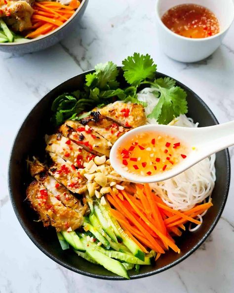 A spoonful of nuoc mum over a bowl of vermicelli bowl salad Lemongrass Chicken Vietnamese, Vietnamese Vermicelli Bowl, Vietnamese Vermicelli, Vermicelli Bowl, Lemon Grass Chicken, Chicken Vermicelli, Ga Nuong, Vietnamese Noodle Salad, Chicken Buns