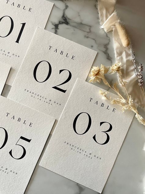 These A5 table names are the perfect personalised addition to your tables. Whether for a wedding or event, personalise your table numbers with your required text and add the finishing touches to your tablescape. These add a modern twist to a classic, simplistic feel. Creating a timeless aesthetic to your event.  D E T A I L S - Each table number is individually designed, bespoke to you.  - Table numbers are printed on high quality 300gm2 textured card, giving a luxe premium feel. - Each table nu Meaningful Table Numbers Wedding, Monochrome Wedding Table Numbers, Black Tie Table Numbers, Cute Table Numbers, Modern Wedding Name Cards, Wedding Design Table, Table Labels Wedding, Deckled Edge Table Number, Minimal Wedding Table Numbers