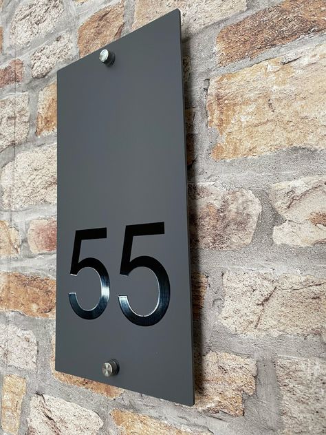 A contemporary house number that will put the finishing touch to the front of your home. This sign is made from a 3mm matt grey or matt black acrylic. The Address is printed using the latest UV printing technology in a wide range of colours. If you want  a colour that is not listed in the dropdown menu please get in contact and we will do our best to match the colour you require. The house number  has a floating effect as it is attached via four stainless steel mounts. All materials are UV stable and weather resistant making this contemporary house sign one of the toughest on the market. Size 150x300mm. All of our house signs come with fixings and fitting instructions provided. Dispatched within 3-5 working days. *Christmas & New Year Dispatch times 2-3 weeks* Contemporary House Numbers, Barbeque Design, Architectural Signage, House Address Sign, Casa Exterior, House Number Sign, Corner House, Black Doors, House Number