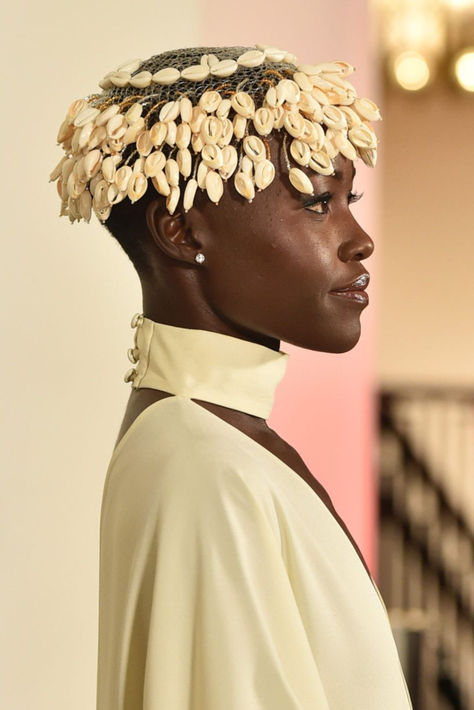 Lupita Nyong'o attended the GO Campaign Annual GO gala looking like royalty with cowrie shells Cowrie Shell Headband, Cowrie Shell Locs, Cowrie Shell Headpiece, Shell Fashion Design, Cowrie Shell Tattoo, Intricate Headpiece, African Headpiece, Shell Headpiece, Knock Door