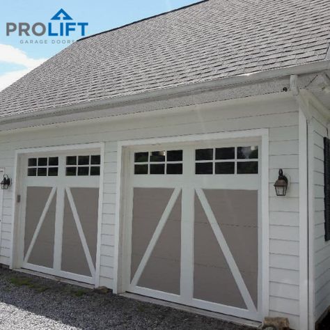 With a two tone factory finish (white overlay with sandstone), these carriage house garage doors bring modern overhead door technology to the home's farmhouse look.  Fully insulated with an R-Value of 18.4 and insulated windows as well, the new doors are energy efficient too. The Clopay Coachman doors have an authentic painted wood look but are made of steel and composite. | Pro-Lift Garage Doors on Houzz | Photo Credits: Pro-Lift Garage Doors Va Two Tone Garage Doors, Painted Wood Look, Cape Hillsborough, Faux Wood Garage Door, Carriage House Garage Doors, Gray House Exterior, Carriage House Garage, Farmhouse Garage, Garage Door Types