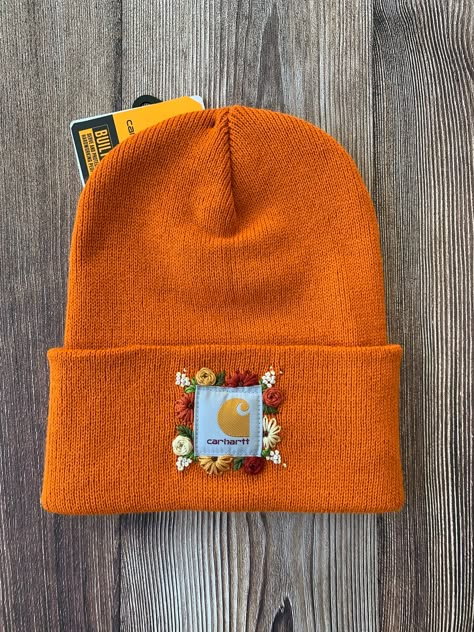 -Authentic Carhartt Knit Cuffed Beanie in the color Marmalade -Size Adult -100% Acrylic  Stand out in the crowd with this tried and true Carhartt beanie embellished with a whimsical hand embroidered floral design. Free-hand design created by me! Hat Hand Embroidery, Embroidered Beanie Floral, Carhart Beanies Embroidered, Hand Embroidery Carhartt Beanie, Easy Embroidery Gifts, Cathartic Beanie Embroidered, Hand Embroidered Carhartt Beanie, Embroidered Carhartt Hat, Embroidery Carhartt Beanie