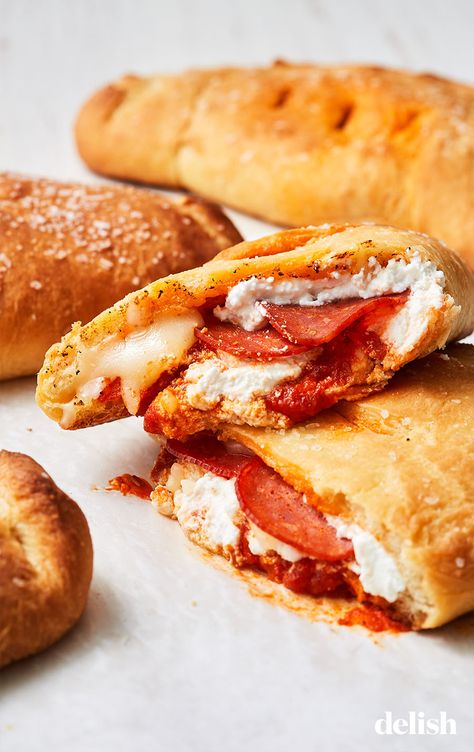 These cheesy, saucy calzones are the ultimate comfort food. Get the recipe at Delish.com. #cheesy #calzone #recipe #easy #withpizzadough #homemade #pepperoni #ricotta Southern Comfort Food Dinners, Italian Calzone, Pizza Dishes, Calzone Recipe, Pizza Pockets, Comfort Food Southern, Comfort Food Recipes Dinners, Comfort Food Recipes, Easy Comfort Food