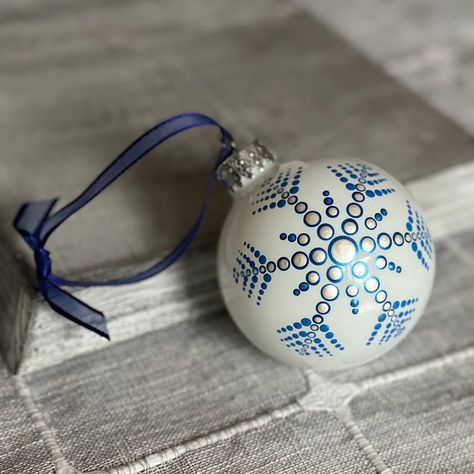 "This beautiful representation of a mandala is an original design and each dot is carefully placed with my hands onto a 2.6\" glass ball ornament using acrylic paint from my small art studio in Portland, Oregon. The ribbon hanger that is pictured with the mandala ornament is included so you can beautifully display this one of a kind art on your holiday tree. Each ornament comes in its own clear acrylic box for safe storage. Mandalas also make wonderful gifts! This is a completed piece but I can do this Mandala in the color scheme of your choice. Please contact me to get started! The meaning of mandala comes from Sanskrit meaning \"circle.\" Even though it may be have features like squares or triangles, a mandala always has a concentric (circular) nature. Mandalas offer balancing visual ele Hand Painted Clear Ornaments, Mandala Snowflake Design, Painted Snowflake Ornaments, Dot Mandala Christmas Ornaments, Paint Christmas Ornaments, Mandala Christmas Ornaments, Christmas Mandalas, Mandala Snowflake, Sanskrit Meaning