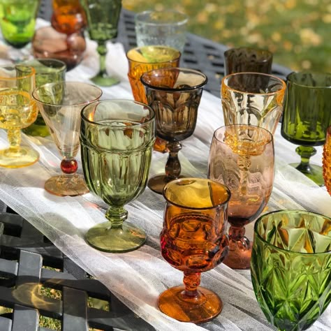 These autumn hued goblets make every toast unforgettable! #vintagerentals #vintagegoblets #fallevents #fallweddings #coloradowedding #coloradofallwedding #coloradoweddinginspiration #vintageweddingdecor #tablescape #cocktailbar #cheers Mismatched Wine Glasses Wedding, Mismatched Goblets Wedding, Wedding Mismatched Glassware, Thrift Glassware Wedding, Vintage Colored Glass Wedding, Wedding Colored Glassware, Thrifted Cups For Wedding, Colored Glass Aesthetic, Thrifted Wedding Table Setting