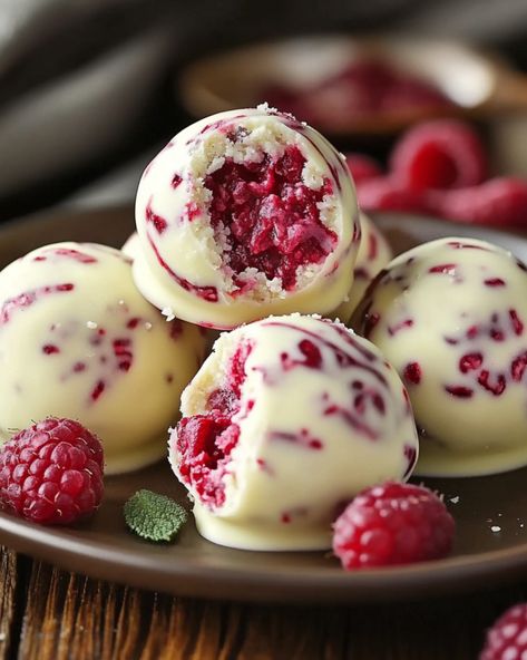 White Chocolate Raspberry Cheesecake Balls - recipestasteful Homemade Chocolates Recipe, White Raspberry Cheesecake Balls, White Chocolate Cheesecake Balls, Nye Baking Ideas, White Chocolate Raspberry Recipes, White Chocolate Raspberry Cheese Balls, Top Rated Desserts, New Years Desserts Party, Raspberry Cheesecake Truffles