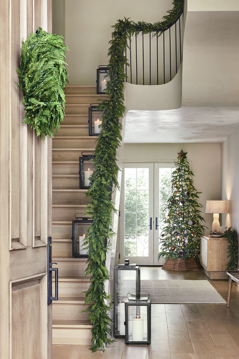 Holiday decor starts here. Shop the very best garland for all your Christmas decor ideas. Our realistic-looking faux botanicals are great for a garland on stairs, garland on mantel, garland over doorway, or anywhere else you want a green Christmas look. Stairs Decorated For Christmas, Staircase Garland Christmas Bows, Garland On Stairs Banisters, Garland Christmas Decor Stairs, Christmas Railing Decor, Garland Hallway, Stairwell Christmas Decor, Banister Garland Christmas, Garland Over Doorway