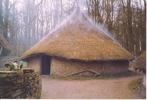 Recreated Celtic Village, Museum of Welsh Life. The open fire within the circular hut gives the thatched roof a "steaming" effect. Three round wattle-and-daub huts are surrounded by a ditch and wooden palisade. (Source: Wikimedia Commons) Celtic Village, St Fagans, Wattle And Daub, Earth Bag Homes, Wooden Hut, Ancient Celts, Thatched Roof, Open Fire, Small Homes