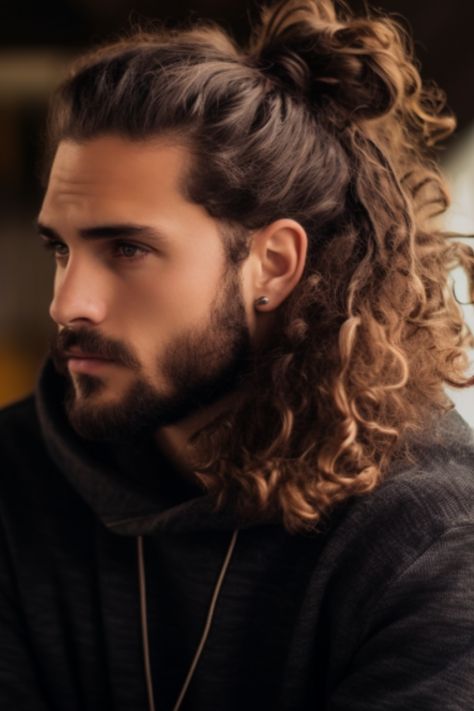 Long curly locks styled into a man bun add a touch to your look. If you have messy curls pulling them up into a man bun at the back of your neck can add an element of sophistication. Click here to check out more best curly hairstyles and haircuts for men. Men Long Hair And Beard Style, Curl Long Hair Men, Long Haired Men Hairstyles, Curly Hair Men Bun, Man Buns Curly Hair, Long Curly Hair Men Ponytail, Wedding Hairstyles Men Long Hair, Wedding Hairstyles For Men Long Hair, Male Long Curly Hairstyles