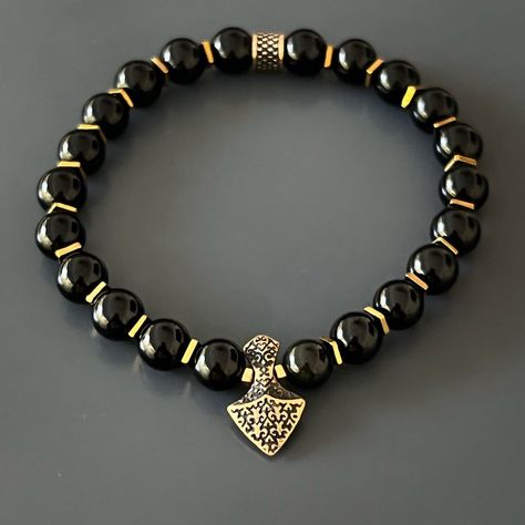 The Arrow Black Onyx Stone Men's Beaded Bracelet is the perfect statement piece for the modern man. The combination of energetically strong black onyx stones and a handmade bronze arrowhead charm creates a unique and powerful design. Black onyx is believed to absorb negative energy and promote inner strength, while the arrowhead symbolizes courage, confidence, and the spirit of a warrior. This handmade bracelet is not only a stylish accessory, but also a powerful tool for spiritual growth and pe Hand Beads For Men, Men Beaded Bracelet Ideas, Bead Business, Cool Mens Bracelets, Art Hacks, Onyx Crystal, Chic Bracelet, The Arrow, Black Onyx Stone