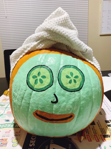 Medium sized pumpkin with green face mask and cucumber eyes, topped with a wrapped towel covering the stem. Pumpkin Face Mask Paint, Self Care Pumpkin Painting, Facial Pumpkin Painting, Halloween Pumkin Ideas Paint, Avocado Pumpkin Painting, Pumpkins Painting Ideas Cute, Fun Carved Pumpkins, Pumpkin Painting Ideas Funny Easy, Cool Halloween Pumpkin Painting Ideas