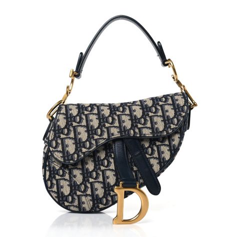 This is an authentic CHRISTIAN DIOR Oblique Mini Saddle Bag in Blue. The chic bag is crafted of navy on beige Dior monogram canvas. The bag features a short leather shoulder strap with a polished brass "C" and "D" anchors on either end of the handle, and a prominent hanging Dior "D" charm. The flap opens to a beige fabric interior. Christian Dior Shoulder Bag, Navy Blue Designer Bag, Doir Bags Mini, Cute Bags Designer, Rare Dior Bag, Blue Dior Bag, Dior Bag Saddle, Dior Mini Bag, Mini Designer Bags