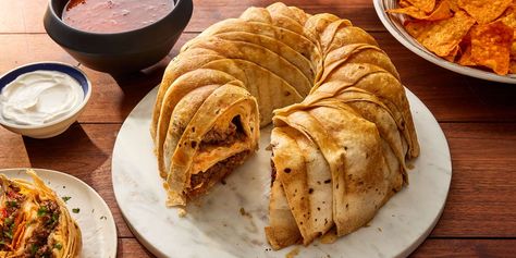 This impressive-looking taco ring is made with flour tortillas encasing a filling of spiced ground beef, two kinds of cheese, and Doritos. Serve with salsa and sour cream. Taco Ring, Creamed Beef, Protein Nutrition, Kinds Of Cheese, Hearty Dinner, Cheese Flavor, 9x13 Baking Dish, Flour Tortillas, Taco Seasoning