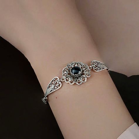 Unveil the elegance of midnight with every flick of your wrist 🌸✨. Our Black Onyx Gemstone Clover Flower Bracelet is a filigree masterpiece that sits pretty on your arm, waiting to cast its charm. Whether you're choosing a Thanksgiving blessing or seeking a memorable birthday surprise, this link bracelet is the whisper of luxury she deserves. Tap to indulge in the enchanting artistry or gift a touch of magic today! 💫🎁 #GemstoneGlamour #CharmHerHeart Find your next treasure here 👉 [https://nu... Silver Bracelet Designs, Silver Flower Bracelet, Flower Woman, Wire Wrapped Jewelry Diy, Art Jewelry Design, Cherry Quartz, Clover Flower, Magical Jewelry, Bird Jewelry