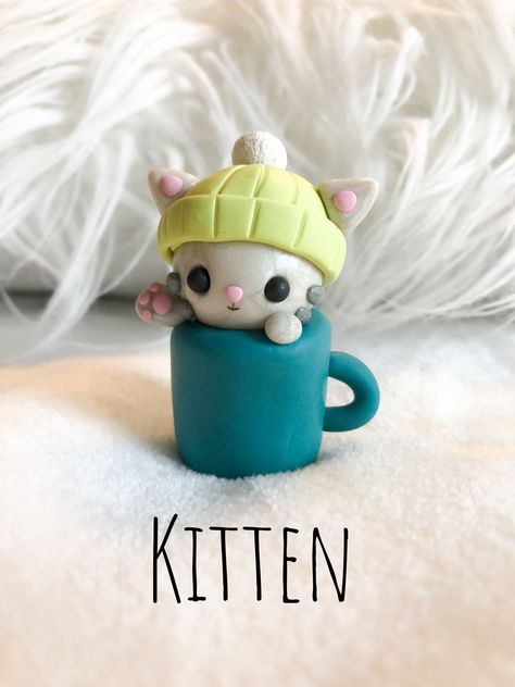 Polymer clay gray kitten wearing a lime green snow hat in a blue-green mug Polymer Clay Cute Animals, Polymer Clay Christmas Ideas, Animal Clay Ideas, Sculpy Clay Ideas Easy, Polymer Clay Kitten, Clay Crafts Cat, Cute Easy Clay Ideas, Cute Polymer Clay Animals, Polymore Clay Ideas