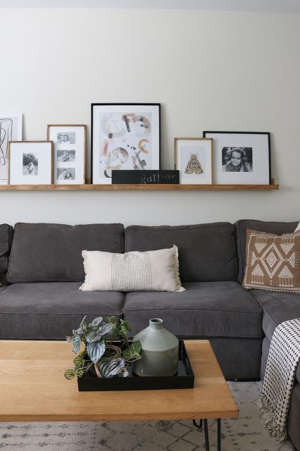 Picture Frame Shelf Ideas, Long Floating Shelf Above Couch, Stacked Picture Frames On Shelf, Floating Shelf With Pictures Above Couch, Ledge Shelf Over Couch, Floating Shelf Behind Sofa, Diy Floating Shelf Behind Couch, Picture Shelf Over Couch, Gallery Wall With Shelf Living Room