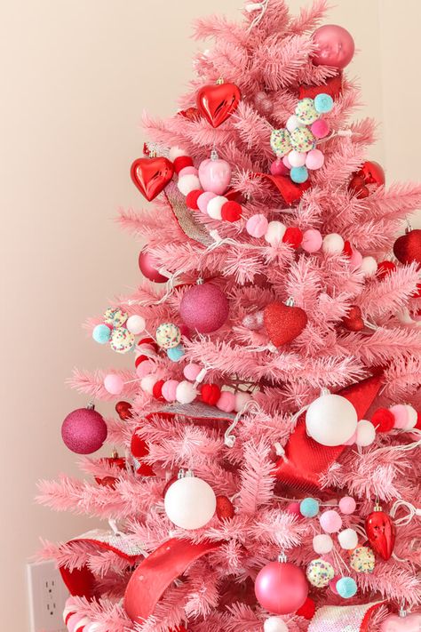 closeup of pink Christmas tree with red, white, and pink pom garland and red heart ornaments, pink glitter ornaments and white ornaments White Christmas Ornaments Aesthetic, Pink And Red Christmas Tree Decorations, Pink Red And White Christmas Decor, Red Pink Christmas Tree, Red And Pink Christmas Decor, Pink Red Christmas Tree, Red And Pink Christmas Tree, Pink Tree Decorations, Mini Pink Christmas Tree