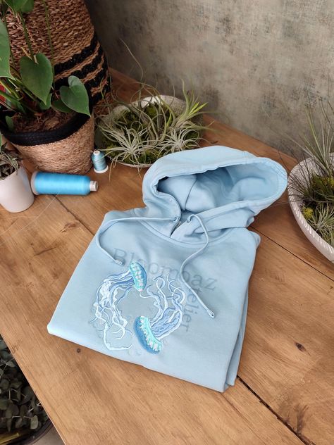 Hey, I'm happy to share my new project with you :)  Water Color Jellyfish Embroidered on Crewneck Sweatshirt, Hoodie Inspired by nature, organic elements and love.  Here's how to wash and take care of your next favorite sweatshirt/hoodie:  1. When to wash the sweatshirt ? I personally don't think that you need to wash it after every use. It needs to be washed after a few wears (five or six).  2. Which washing machine program should you use?  Turn the sweatshirt inside out and use the delicate or hand wash programs to respect the material. Unisex size for adults. Unisex size with variable sizes from XS to 3XL. Enjoy and contact me if you have any questions! Cute Hoodies Aesthetic, Embroidered Jellyfish, Blue Clothes Aesthetic, Hoodie Inspiration, Sea Outfit, Washed Sweatshirt, Embroider Ideas, Hoodie Diy, Organic Elements