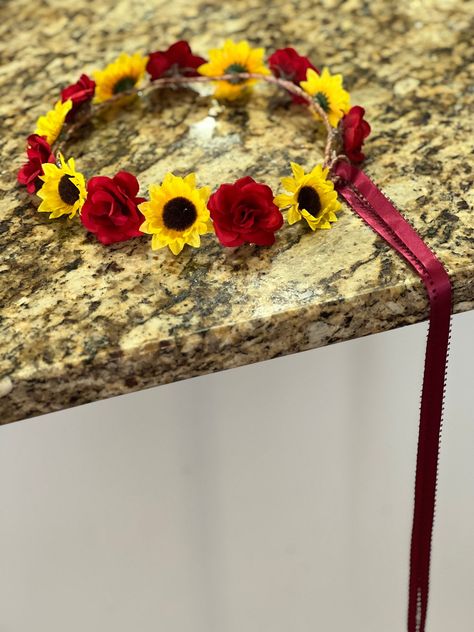 This listing is for one (1)  simple but pretty adjustable small open rose and sunflower  halo with long ribbon streamers available in your choice of ribbon colors. Burgundy ribbon shown.   Roses are available in red, off white and ivory.  If not specified, red roses will be used Shipping is via USPS first class mail insured.   Nothing pleases me more than when people share their pictures with me of people wearing my headpieces, corsages or using my kiss balls  I LOVE receiving pictures!   If you do share, WITH OUR PERMISSION ONLY,  I will give honorary mention - first name only as well as your photographer!  I do not share pictures of their faces unless I receive permission, especially of children, so be sure to tell me if it is okay.  Thank you for looking! Red And Sunflower Wedding, Rose And Sunflower Wedding Theme, Red And Yellow Wedding Theme, Sunflower And Burgundy Wedding, Rose Sunflower Wedding, Burgundy And Sunflower Wedding, Rose And Sunflower Bouquet, Sunflower Burgundy Wedding, Sunflower And Rose Wedding