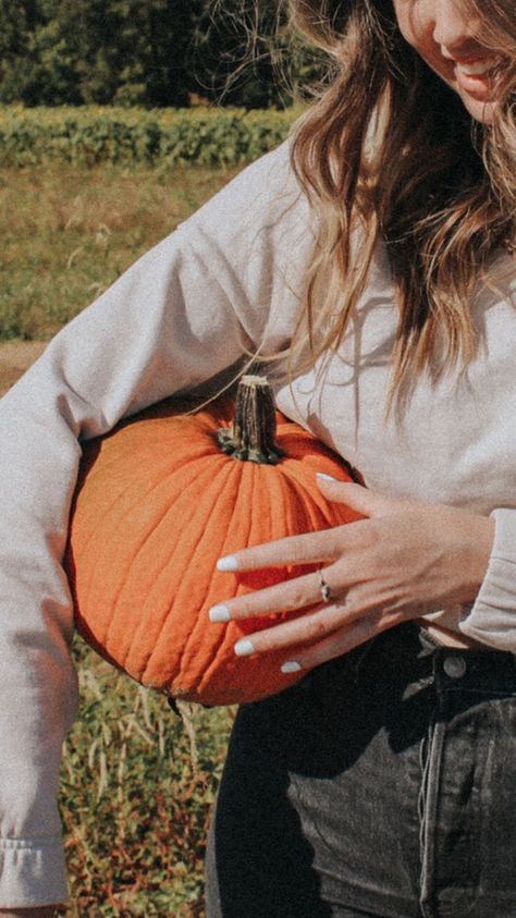 Carolynn is holding a bright orange pumpkin between her hip and her arm. She's wearing a beige crop sweater, black jeans, and her hair is curled. She's smiling down at the pumpkin, but her face is cut off in the top right corner of the photo. Pumpkin Picking Aesthetic, Pumpkin Patch Photography, Fall Vsco, Pumpkin Aesthetic, Pumpkin Patch Photoshoot, Pumpkin Field, Pumpkin Patch Pictures, Pumpkin Pictures, Rainy Day Aesthetic