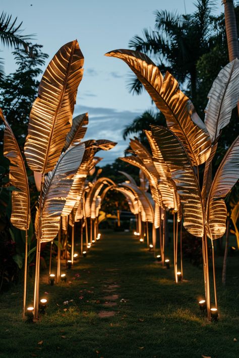 Make a Grand Entrance: Gilded Tropical Leaves & Candlelit Pathway Ideas  - Evening Wedding Ideas Indoor Tropical Wedding Ceremony, Elegant Tropical Party, Evening Wedding Ideas, Elegant Wedding Venue Ideas, Glam Party Decor, Tropical Glam Decor, Golden Wedding Decor, Island Wedding Ideas, Reception Venue Decorations