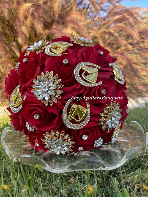 A beautiful vaquero themed bouquet for your special occasion. This bouquet is handmade to order with red silk roses, gorgeous sparkling gold brooches and rhinestones. We can do it in different colors. Please select the color of your choice. Please message me if you would like silver brooches instead.  *This bouquet is 10 inches in diameter* Please contact me with any questions! :) Red And Gold Roses Quinceanera Theme, Red Vaquero Quince, Quince Bouquet Red, Red Quince Bouquet, Vaquero Quinceanera Theme, Chambelanes Outfits Quinceanera Red, Red And Gold Quinceanera Theme, Red And Gold Quinceanera Decorations, Quince Chambelanes Outfits