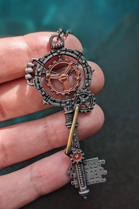 close-up of a hand holding a steampunk key necklace Steampunk Props Diy, Cool Key Designs, Steampunk Symbols, Steampunk Astethic, Steampunk Aesthetic Dark, Diy Steampunk Accessories, Minimalist Steampunk, Clock Punk, Aesthetic Keys