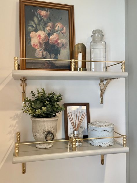 Romantic Vanity Decor, French Inspired Bathroom Decor, Gallery Shelves Living Room, Guest Bathroom Brown Cabinets, Bathroom Inspiration Vintage, Shelves With Gallery Rails, Adding Antiques To Modern Home, French Decor Aesthetic, Nancy Meyer Bathroom