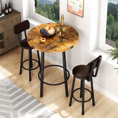 Create a beautiful interior relaxing space with this stylish and contemporary 3-piece pub table set. It will surely satisfy your demands for beauty and practicality. This small and compact dinette is the perfect setting for intimate dining in small spaces such as apartments, studios, or your home's kitchen. Chairs are ergonomically crafted with curved backrests to promote healthy posture. A great addition for all home and small dining spaces. Table Top Color: Vintage Brown | Millwood Pines Akill Small Round Dining Tables, Small Kitchen Table Ideas, Round Kitchen Table And Chairs, Bar Table And Chairs, Cozy Kitchen Nook, Pub Dining Set, Kitchen Table Ideas, Small Kitchen Table, Round Pub Table