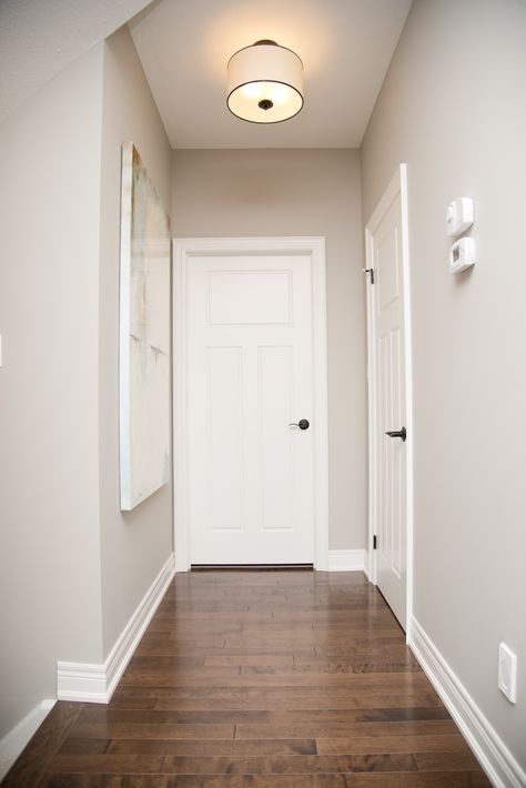 A neutral wall colour paired with bright white trim complemented this flooring beautifully. #parliamentpainting #housepainting #homedesign #hamont Internal House Paint Colors, White Wall And Door Color Combination, Internal Paint Colours Wall Colors, Door And Wall Colour Combination, Color Trim White Walls, Wall And Floor Color Combination, Floor And Wall Color Combinations, Neutral Wall Paint, Hallway Colour Schemes