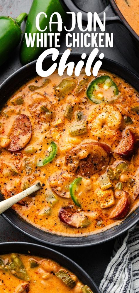 A close up overhead view of a bowl filled with Cajun white chicken chili, sitting next to a second bowl and some whole jalapeno peppers. White Chili With Sausage, Cajun Chicken Pasta Chilis, Cajun Chicken Pasta Soup Crockpot, Cajun Shrimp Pasta Chilis, Cajun Chicken Soup Crock Pot, Seafood Chili Recipe, Keto Creamy Cajun Chicken Soup, Cajun Chicken Soup, Seafood Chili