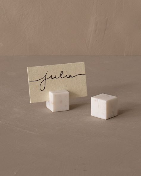 Effortlessly guide your guests to their seats with our Marble Place Card Holder Set. Each piece, crafted from elegant marble, is designed with a slot to hold a name card, adding an unexpected element of sophistication to your event. But its use goes beyond seating arrangements. We like to these holders for displaying cheese types on a serving board, presenting wine varietals during a tasting session, or labeling dishes during a gathering. Their versatility also makes it a perfect gift for the di Wedding Table Decorations Name Cards, Place Markers Wedding, Unique Table Name Cards, Name Holders For Wedding, Ceramic Place Card Holders, Ceramic Place Cards, Stone Place Cards, Unique Name Cards Wedding, Placecards Wedding Table