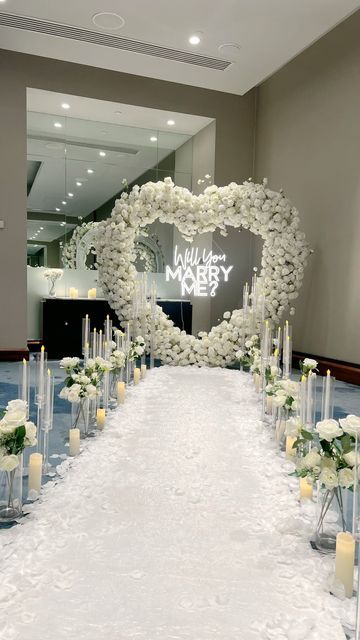 Event Planning | Design | Decor on Instagram: "That one time you thought you are going to a work conference but instead you got PROPOSED TO 🥹💍  We turn proposals into core memories you’ll treasure forever 🤍  Our stunning white floral heart arch is the ultimate backdrop for your love story.  Would you like a surprise proposal?" Wedding Proposal Backdrop, White Proposal Decor, Proposal Backdrop Ideas, Proposal Arch, Heart Wedding Arch, Black Proposal, Floral Proposal, Proposal Ideas At Home, Wedding Proposal Ideas Engagement