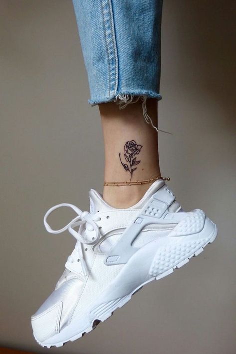 grey-background-small-tattoo-ideas-for-women-jeans-white-sneakers-gold-ankle-bracelet Rose Tattoo On Ankle, Tattoo Placements, Unique Small Tattoo, Ankle Tattoos For Women, Small Rose Tattoo, Small Flower Tattoos, Small Girl Tattoos, Inspiration Tattoos, Wrist Tattoos For Women