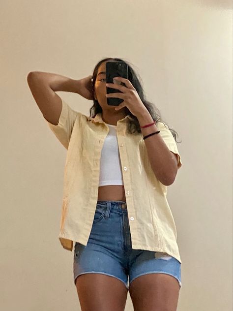 A women taking a mirror selfie of her outfit; a white tank top with a yellow  short sleeve button up and jean shorts. Shorts Top Outfit, Button Down And Shorts Women Outfit, Short Button Up Shirt Outfit, Short Sleeve Button Up Shirt Outfit, Short Sleeve Button Up Outfit Women, White Tank Top Outfit Aesthetic, Shorts And Button Up Shirt, Tank Top Shorts Outfit, Outfit Jean Shorts