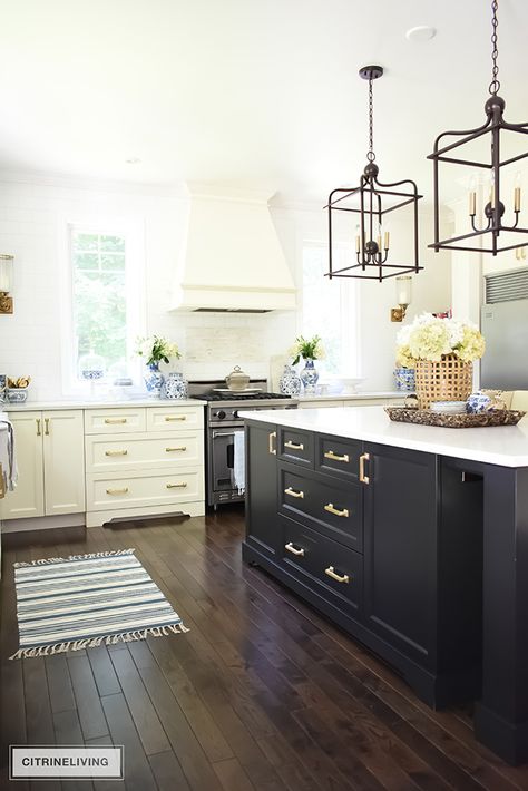 White kitchen with black island, pendant lighting over island, oak hardwood floors. If you like this kitchen,  you have to see the whole tour! pin now read later! #kitchen #kitchens #kitchenideas #black&white #black&whitekitchen Cream Kitchen Cabinets With Dark Island, White Cabinet With Black Island, Black Island Dark Floors, Dark Island Dark Floors, Cream Cabinets Dark Island, Dark Cabinets Brass Hardware, Black Island Cream Cabinets, Cream Cabinets With Brass Hardware, Cream Kitchen Cabinets With Black Island