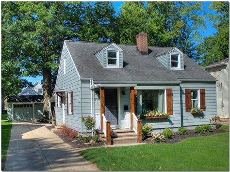 Bungalow renovation with gray siding, wood board and batten shutters, portico and window boxes. Light Grey House With Wood Shutters, Wood Shutters On Gray House, Gray House With Wood Shutters, Wood Shutters And Window Boxes, Blue House Cedar Shutters, Board And Batten Shutters On Siding, Grey House Wood Shutters, Blue House Wood Shutters, Grey House With Wood Shutters