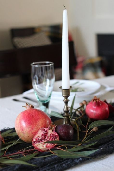 a simple and pretty fall centerpiece of a table runner, greenery, pomegranates and plums plus a tall candle Table Runner Greenery, Pomegranate Wedding, Pomegranate Decor, Winter Fruit, Fall Home Tour, Wine Dinner, Tall Candle, Red Pomegranate, Dinner Decoration