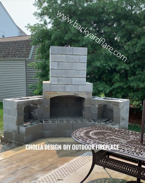 DIY Outdoor Fireplace built from cinderblock and mortar. Concrete and steel inside with firebrick. outdoor patio furniture in front of the fireplace. Poured concrete seating hearth. Green trees and grass in background. Corner designed Cholla design. Outdoor Fireplace Plans, Outside Fireplace, Diy Outdoor Fireplace, Outdoor Fireplace Designs, Cinder Blocks, Outdoor Fireplace Patio, Patio Small, Patio Fireplace, Backyard Fireplace