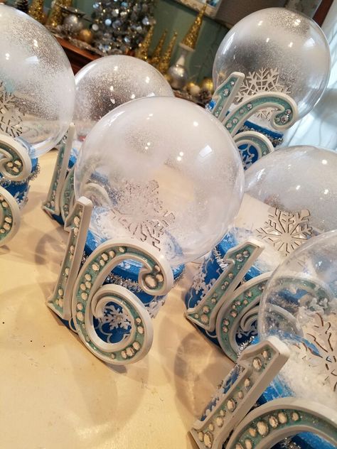 I used acrylic light covers and boxes from the dollar store to create these snowglobe centerpieces. A little sprinkle snow and spray snow added the final touch!  added some snowflake and small silver tinsel to add that winter Wonderland touch. Winter Wonderland Quince, Diy Decorations Party, Quinceanera Winter Wonderland, Quince Decorations Ideas, Winter Wonderland Quinceanera, Spray Snow, Sweet 16 Winter Wonderland, Sweet 16 Winter, Winter Wonderland Party Theme