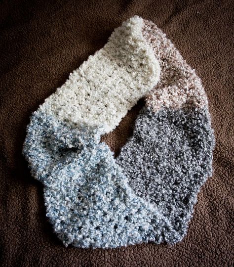 "The Homespun Infinity Scarf is fluffy and warm. It is crocheted with a boucle yarn for a nice texture, in an openwork stitch to keep it light. The yarn is self-striping in four colors, black, ivory, brown, and blue. The scarf is crocheted from one end to the other, then a single twist is added before stitching the ends together. The only stitches used are single crochet and chain. The sc are worked in the center of the sc below, creating a strong vertical line with fewer loose strands. Boucle Yarn Patterns Crochet, Fuzzy Scarf, Single Twist, Crochet Scarf Pattern Free, Boucle Yarn, Crochet Infinity Scarf, Valentines Crochet, All Free Crochet, Knitted Wit