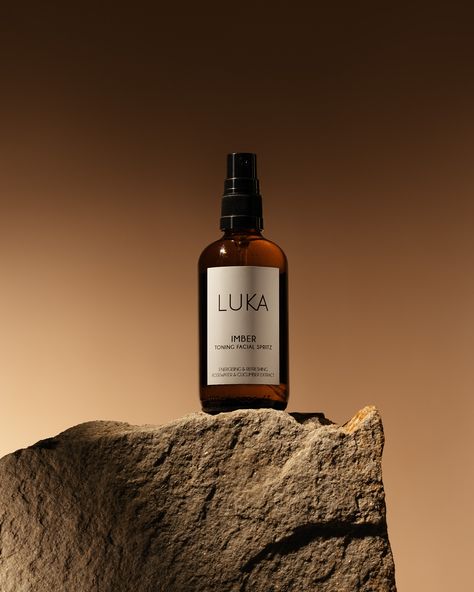 Promotional product photography of the product. Brown skincare spray LUCA Imber with toning facial spritz. Toner contains rosewater and cucumber. The product stands on a large brown stone, the sun creates a beautiful shadow in the background. How To Shoot Product Photography, Product Photo Editing, Product Photography Luxury, Facial Product Photography, Backgrounds For Products, Skin Care Photography Products, Beauty Products Photoshoot, Brown Product Photography, Beauty Product Photoshoot Ideas