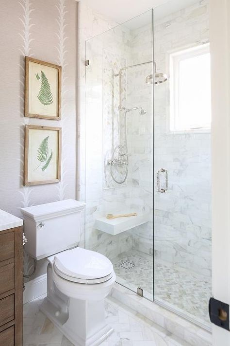 Schumacher Acanthus Stripe Wallpaper decorates the walls of a transitional bathroom boasting a glass walk-in shower finished with Calcutta gold marble herringbone floor tiles. Calcutta Bathroom, Acanthus Stripe Wallpaper, Quartz Shower Walls, Calcutta Gold Marble Bathroom, Quarter Bathroom, Calcutta Quartz, Herringbone Shower Tile, Marble Herringbone Floor, Herringbone Shower