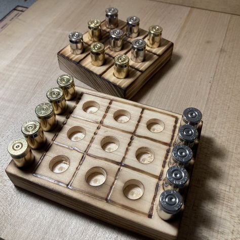 "Tic Tac Toe game with a rustic look and a spin of freedom using the caliber casing of your choice in brass and nickel for the pieces. The board is made from either pine or oak and has been given a burned finish. There are 2 versions, the simple just plain board with pieces, and the deluxe version with storage for the pieces on the side. Each board comes with 10 polished casings (5 brass, 5 nickel plated). Perfect for that quick game to challenge your friends with in your man cave, at a bar, or Cute Woodworking Projects, Diy Shop Ideas, Simple Crafts To Sell, Bullet Casing Crafts, Shotgun Shell Crafts, Bullet Crafts, Bullet Casing, Cool Wood Projects, Wood Projects That Sell