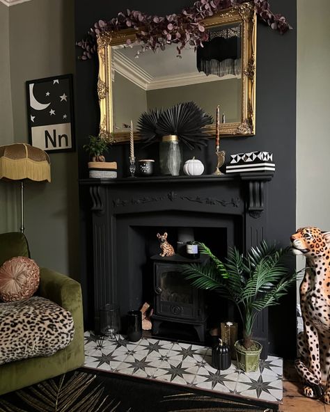 A black fireplace with Victorian style decorations and a faux leopard Maximalist Living Room, Black Fireplace, Maximalist Home, Dark Home Decor, Dark Home, Boho Curtains, Faux Fireplace, Mirror On The Wall, Maximalist Decor