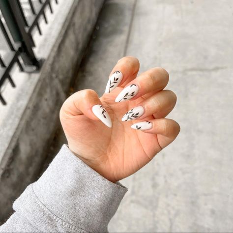 White Based Acrylic Nails, Black And White Almond Acrylic Nails, Black Nails With Leaves, Black And White Nails With Flowers, White Nails With Vines, White Nails With Leaves, White Nails With Black Flowers, Black And White Floral Nails, White Nails With Green Designs