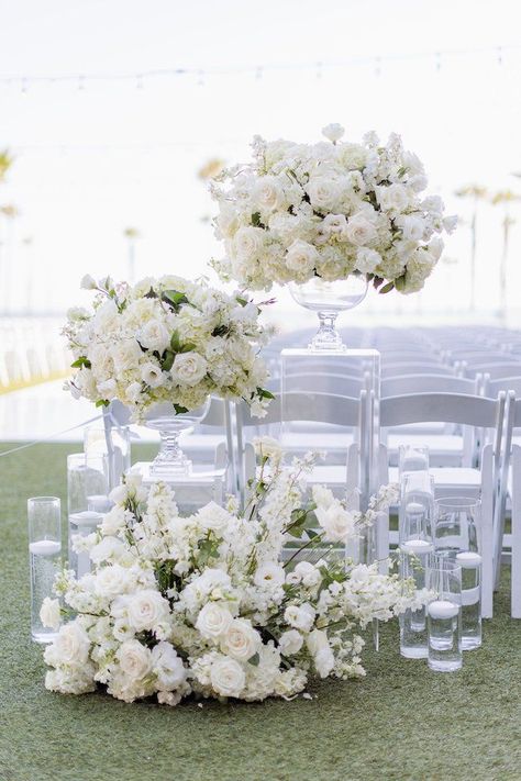 Overhanging Flowers Wedding, Wedding Flowers Floor Arrangements, Pedestal Flowers Wedding Ceremony, White Folding Chairs Wedding Ceremony, Ivory Wedding Florals, Floor Florals Wedding Ceremony, Tall Arrangements Wedding, White Aisle Arrangements, Wedding Decor White Flowers